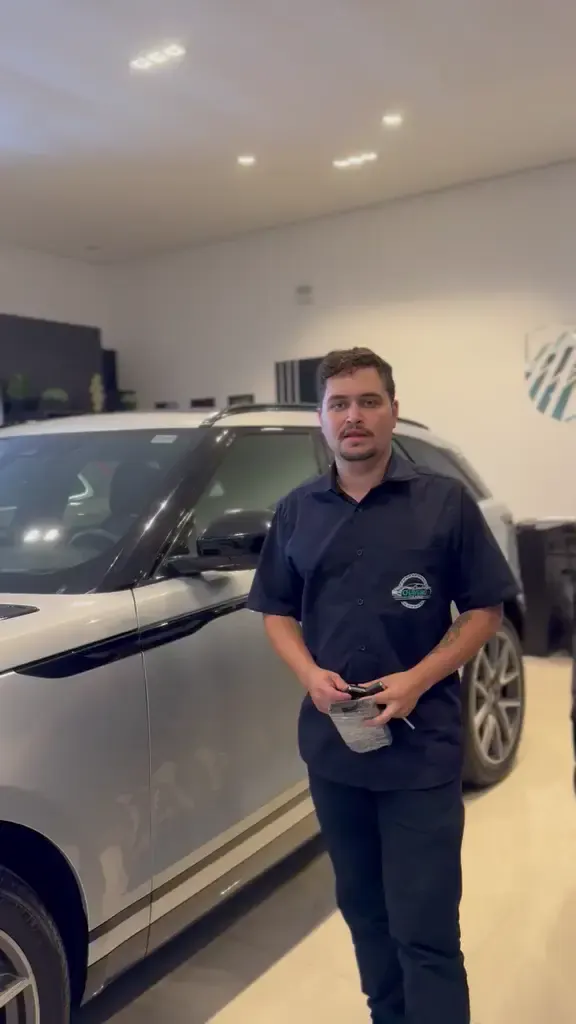Arthur Colares de uniforme ao lado de um Range Rover Velar